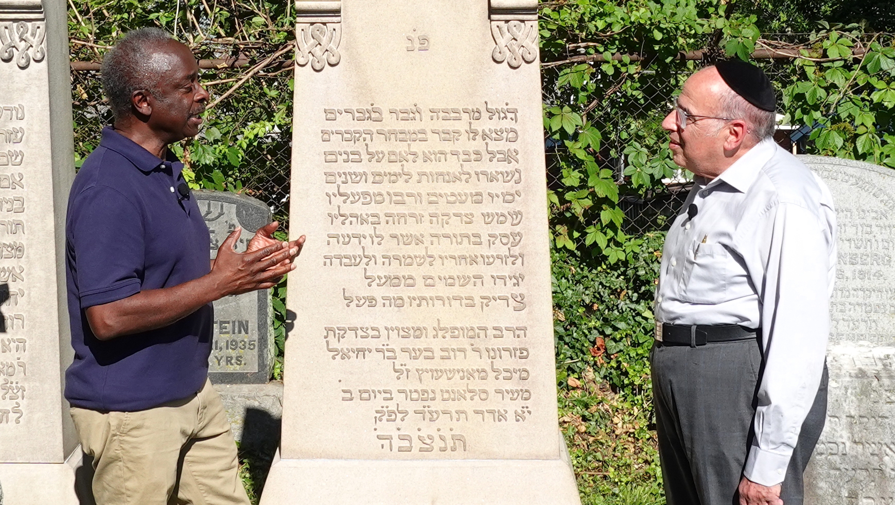 For “World’s Greatest Cemeteries'' public television series: (center) Host/Producer Roberto Mighty and (right) Jack Rabinstein, Trustee Emeritus, Jewish Cemeteries of Greater Cincinnati, in front of the grave of Food Manufacturer Rabbi Dov Behr Manischewitz. Season 2-episode WCEM_203_Jewish Cemeteries of Greater Cincinnati. Photo by Celestial Media LLC